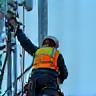 Technician installing antennas on a tower
